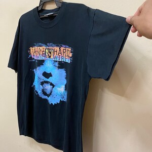 May include: Black t-shirt with a graphic print of a blue and pink face with the text "Front 242 Hard Wired" on the front.