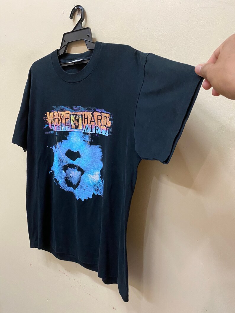 May include: Black t-shirt with a graphic print of a blue and pink face with the text "Front 242 Hard Wired" on the front.