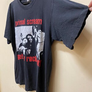 May include: Black t-shirt with a white and red graphic print of a band called "Primal Scream" with the text "Get Rock Off".
