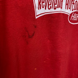 May include: Red t-shirt with a white graphic that says "The Reverend Horton Heat" with a cartoon image of a person wearing a hat and holding a guitar.