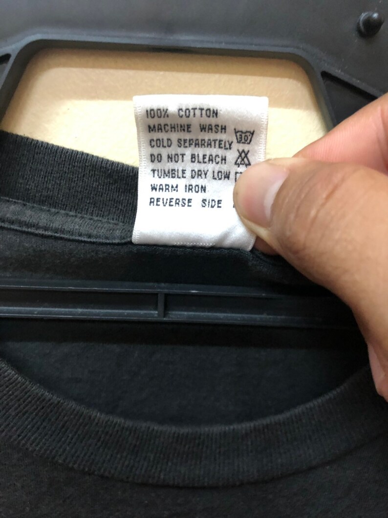 May include: White care label with black text that reads "100% Cotton, Machine Wash Cold Separately, Do Not Bleach, Tumble Dry Low, Warm Iron, Reverse Side". The label has a 30 degree symbol and a symbol that looks like a cross through a circle.