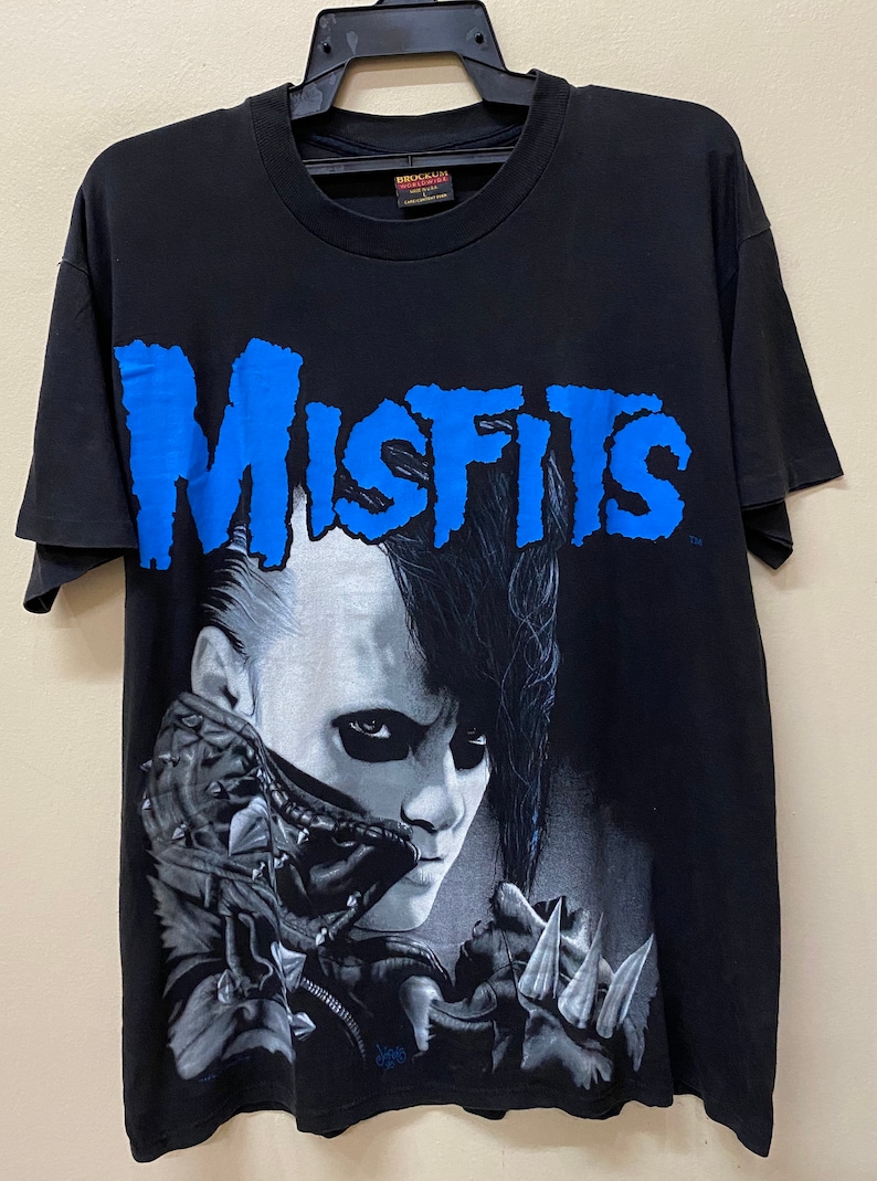 May include: Black t-shirt with a blue "Misfits" graphic and a black and white image of a person with a mohawk.