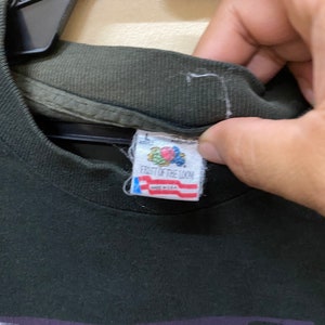 Pu&ograve; includere: Una maglietta nera con una stampa grafica di una creatura della laguna nera. La maglietta &egrave; realizzata da Fruit of the Loom ed &egrave; realizzata negli Stati Uniti.