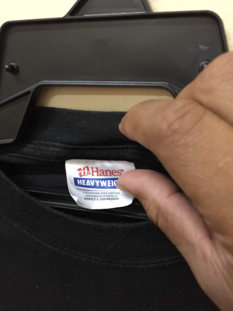 May include: Black Hanes Heavyweight t-shirt tag with white text. The tag reads "Preshrunk 100% Cotton, Assembled in Mexico, Adult L (42-44)/G/G".
