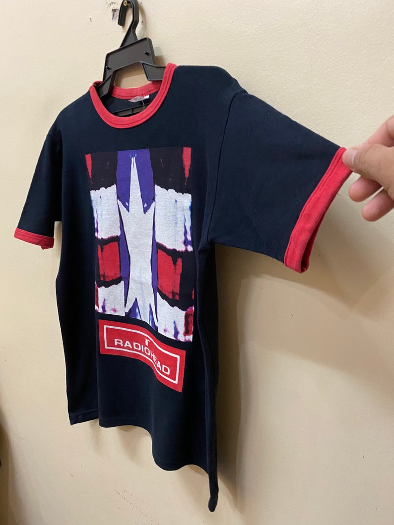 May include: Black t-shirt with a red and blue graphic print of a star and the word "RADIOHEAD" in a red box.