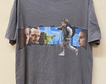 Peut inclure: T-shirt gris avec un graphique Star Wars Episode I représentant des personnages du film. Le graphique comprend Anakin Skywalker, Qui-Gon Jinn, Obi-Wan Kenobi, Yoda et Padmé Amidala.