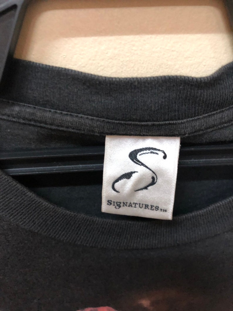 May include: Black t-shirt with a white tag that says "Signatures" and a stylized "S" logo.