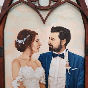 May include: A painting of a bride and groom in a wedding portrait. The bride is wearing a white dress with lace detailing and a floral crown. The groom is wearing a blue suit with a white shirt and a bow tie. They are looking at each other with smiles on their faces.