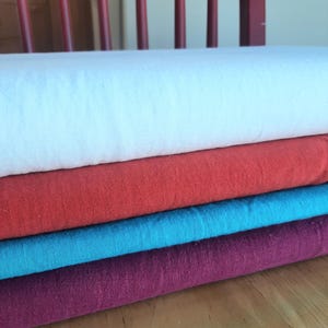 May include: A set of three ceramic mugs with a speckled, matte finish. The mugs are in shades of cream, light gray, and dark gray. Each mug has a simple, minimalist design, perfect for coffee or tea.