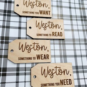May include: Four wooden gift tags with the name Weston and a category for the gift. The categories are: Something You Want, Something to Read, Something to Wear, and Something You Need.