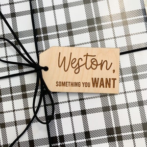 May include: A wooden gift tag with the name Weston and the text "something you want" in black lettering on a white and black plaid background.