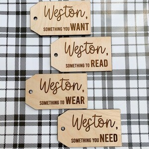 May include: Four wooden gift tags with the name Weston and a category for the gift. The categories are something you want, something to read, something to wear, and something you need.
