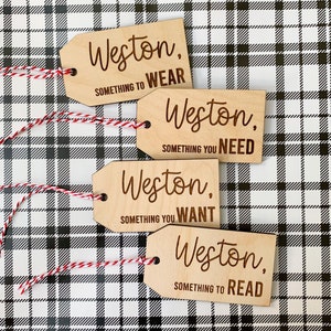 May include: Four wooden gift tags with the name Weston and a phrase on each. The phrases are "Something to Wear", "Something You Need", "Something You Want", and "Something to Read".