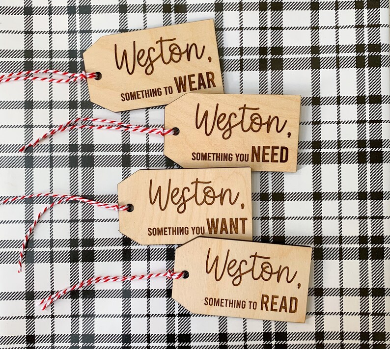 May include: Four wooden gift tags with the name Weston and a phrase on each. The phrases are "Something to Wear", "Something You Need", "Something You Want", and "Something to Read".