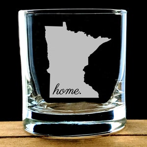 May include: A clear glass shot glass with an etched outline of the state of Minnesota and the word "home."
