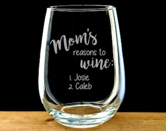 May include: A clear glass wine glass with the text "Mom's reasons to wine: 1. Josie 2. Caleb" etched on the side.