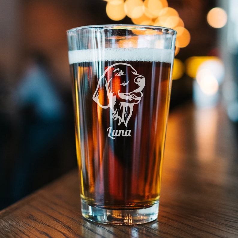 A pint glass with a Golden Retriever design etched on the front with the name "Luna".