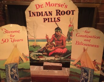 May include: Vintage advertisement for Dr. Morse's Indian Root Pills, featuring a Native American man preparing medicine in a mortar and pestle. The text reads "Favored for 50 Years" and "for Constipation and Biliousness".