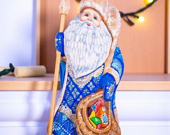 プレゼントボックスのフィギュアと一緒にアイススケートをするサンタ