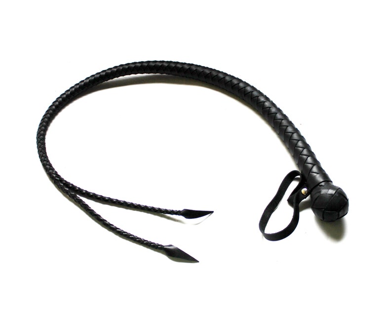 May include: A black leather braided whip with a rounded end and a black strap.
