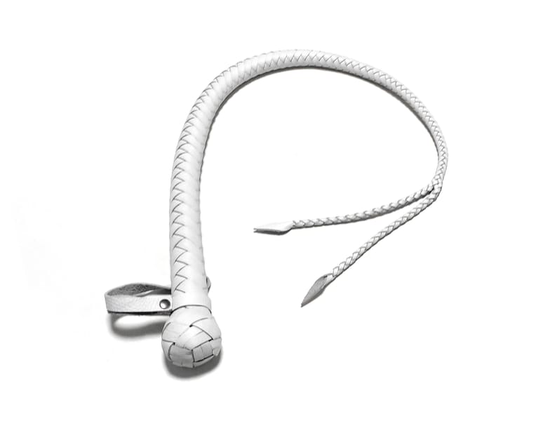 May include: A white leather bullwhip with a braided handle and a loop at the end.
