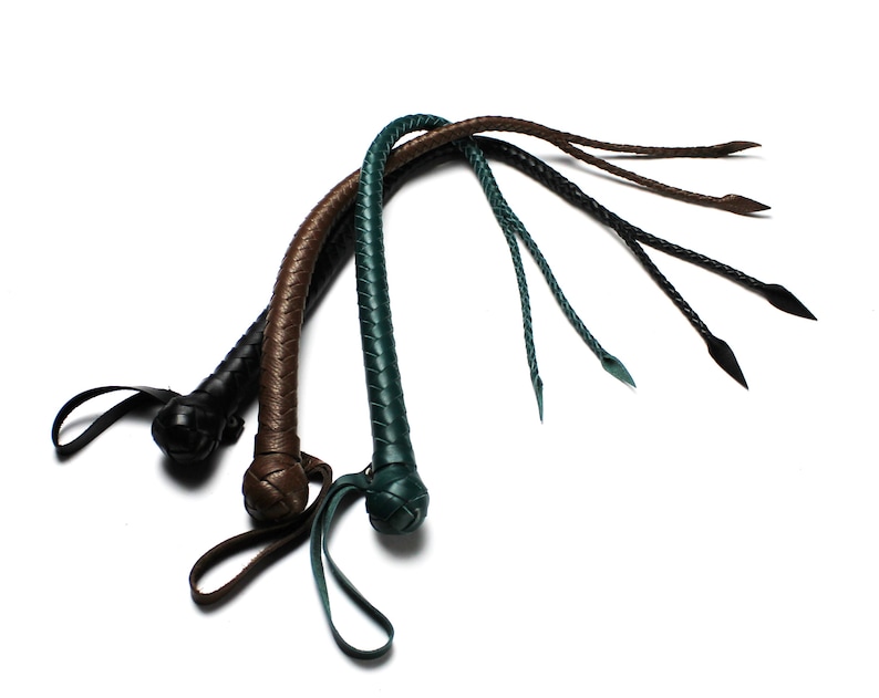 May include: Three leather whips with braided handles in black, brown, and green.