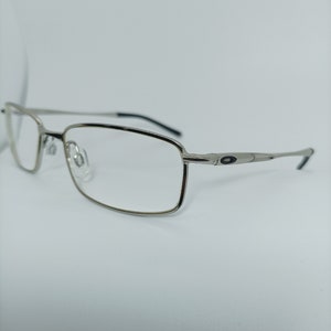 Puede incluir: Gafas rectangulares plateadas con detalles negros en las patillas.