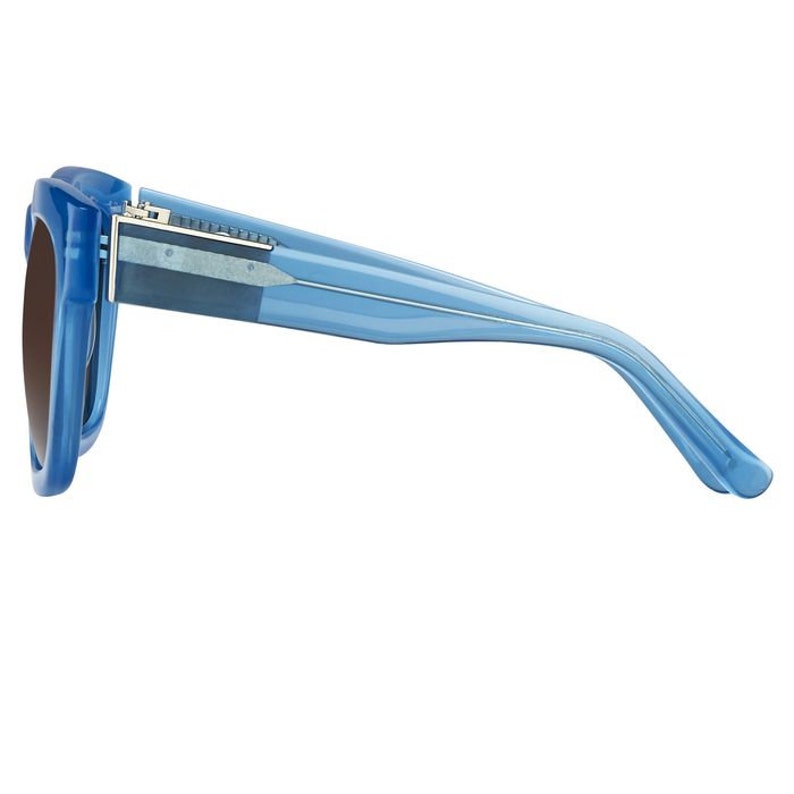 K&ouml;nnte beinhalten: Eine blaue Sonnenbrille aus Kunststoff mit einem silbernen Akzent auf der Br&uuml;cke. Die Sonnenbrille hat eine quadratische Form und wird von der Seite gezeigt.