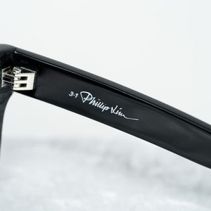 Puede incluir: Gafas de sol negras con el logotipo de 3.1 Phillip Lim en la varilla.