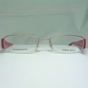 May include: Pink eyeglasses with a stainless steel frame and Giorgio Armani branding.