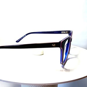 May include: Black-framed eyeglasses with a purple and blue accent. The glasses have a square shape and a small diamond detail on the side. The temples are a dark blue color. The lenses are a light blue color.