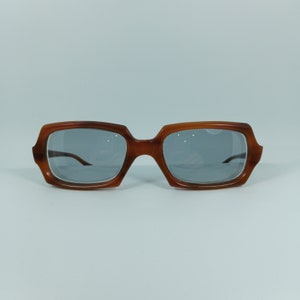 May include: A pair of brown tortoise shell framed glasses with gray lenses.