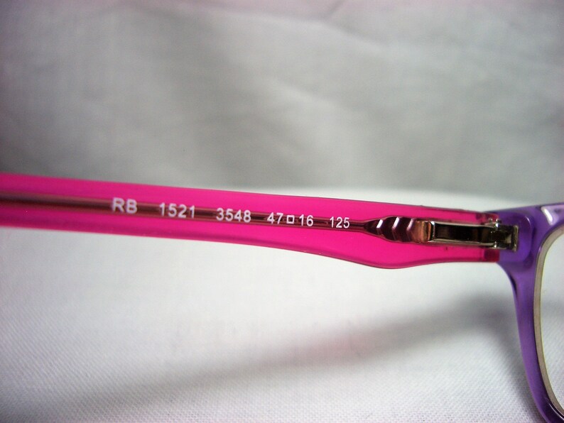 Puede incluir: Gafas de vista de color rosa y morado con el texto "RB 1521 3548 47□16 125" impreso en la montura.