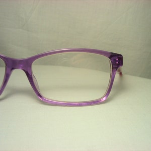 Puede incluir: Gafas de pl&aacute;stico de color morado con lentes transparentes.