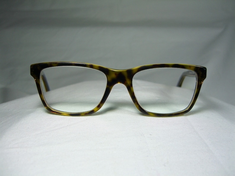 May include: Tortoise shell eyeglasses with a rectangular frame and clear lenses.