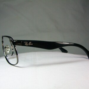 K&ouml;nnte beinhalten: Schwarze und silberne Ray-Ban Brille mit einem d&uuml;nnen Metallrahmen und schwarzen Kunststoffb&uuml;geln.