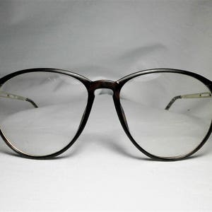 May include: A pair of brown tortoiseshell eyeglasses with round lenses and a silver metal bridge.