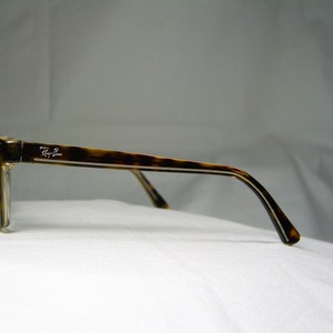 May include: Tortoise shell eyeglasses with a silver Ray-Ban logo on the side.