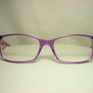 Puede incluir: Gafas de pl&aacute;stico de color morado con lentes transparentes.