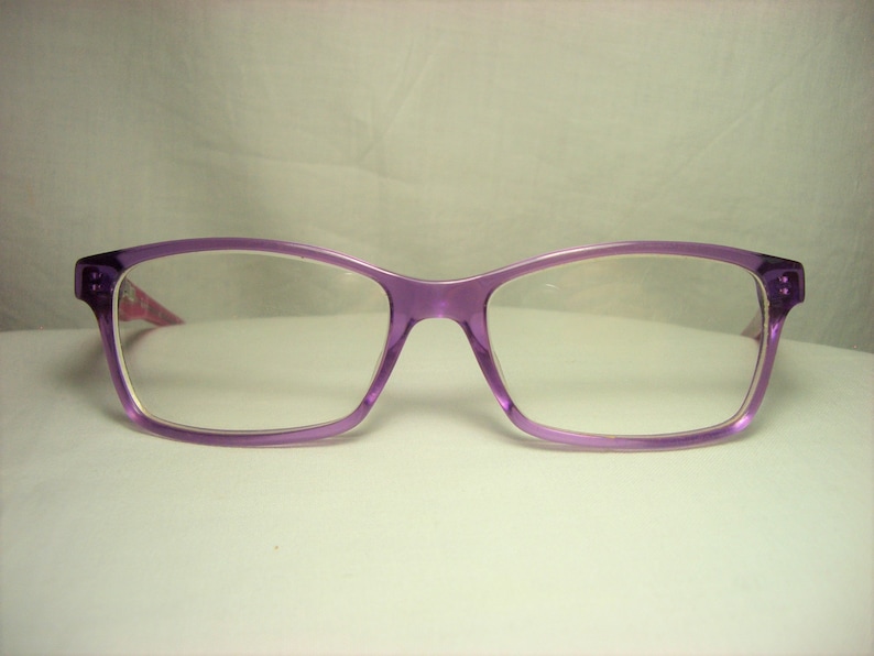 Puede incluir: Gafas de pl&aacute;stico de color morado con lentes transparentes.