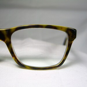 May include: Tortoise shell eyeglasses with a rectangular frame and clear lenses.