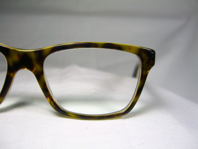 May include: Tortoise shell eyeglasses with a rectangular frame and clear lenses.