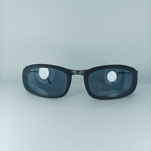 Op de afbeelding: Zwarte rechthoekige zonnebril met donkergrijze glazen.