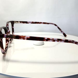 Peut inclure: Lunettes &agrave; motif &eacute;caille de tortue marron et violet. Les montures sont rectangulaires avec une l&eacute;g&egrave;re forme &oelig;il de chat. Le logo Roxy est visible sur la branche.