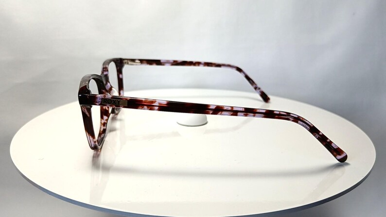 Peut inclure: Lunettes &agrave; motif &eacute;caille de tortue marron et violet. Les montures sont rectangulaires avec une l&eacute;g&egrave;re forme &oelig;il de chat. Le logo Roxy est visible sur la branche.