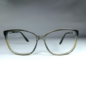 May include: A pair of tortoiseshell spectacles with a cat-eye frame and clear lenses.