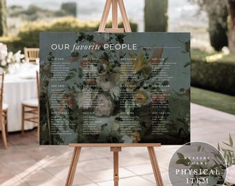 May include: A wedding seating chart on an easel. The sign reads "OUR favorite PEOPLE" above a floral design. The chart lists names under table numbers. The sign is a physical item.