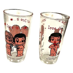 May include: Two clear glass tumblers with cartoon illustrations. One features figures holding flowers, the other a figure on a phone. Text includes "love is" and "giving and forgiving."