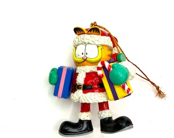 Gorgeous collectible and vintage ornament as Garfield As Santa Claus with present, trim-a-tree ornament . With the original box.