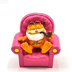 Gorgeous collectible and vintage Garfield oldie but goody! with a pink sofa, orange, cat, sports, old, pipe, Garfield.